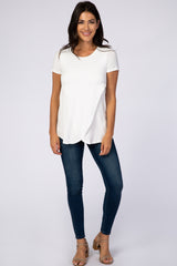 woman wearing white short sleeve nursing top with tulip hem and dark wash skinny jeans