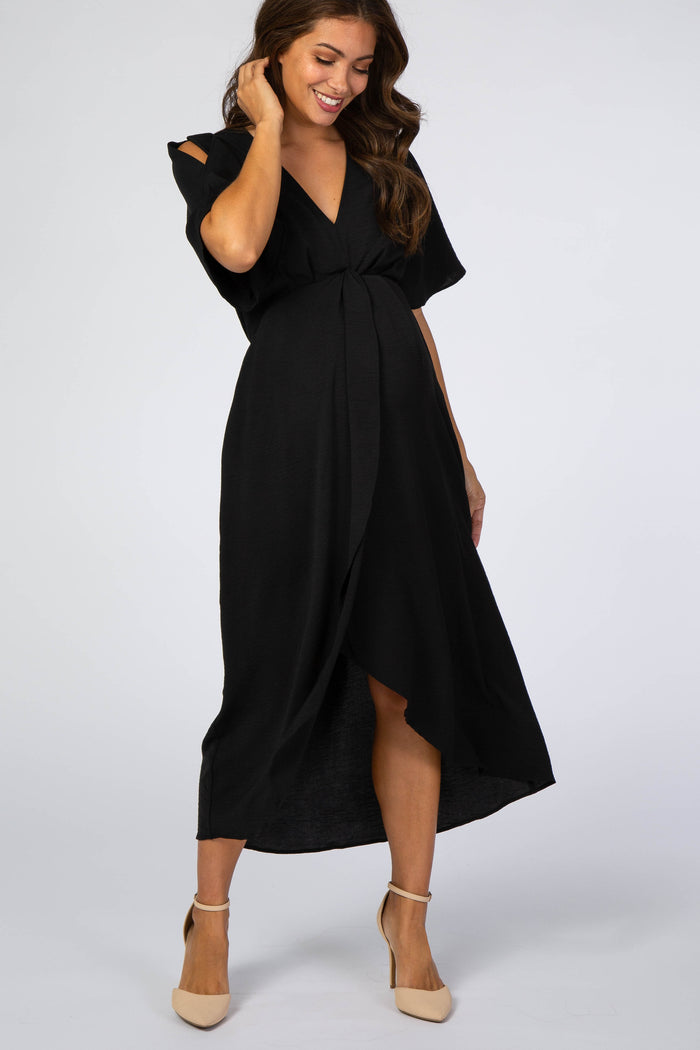 woman wearing a black maternity wrap dress with short sleeves and a knotted detail, showing her baby bump