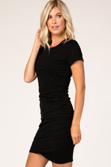 woman wearing a black short sleeve fitted dress with gathered side details