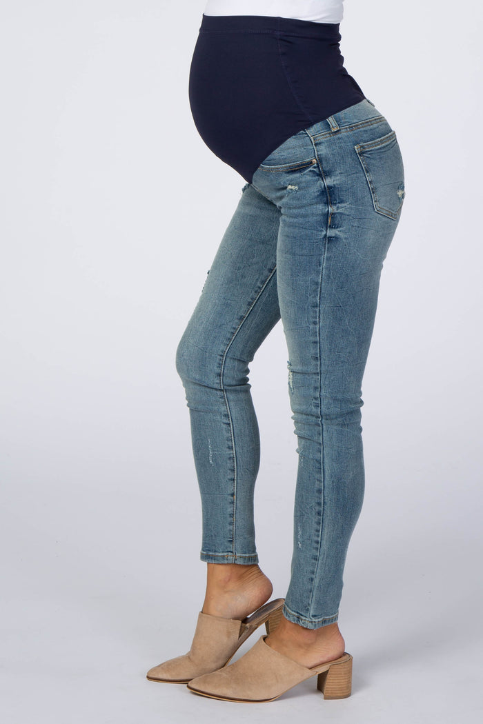 woman wearing dark blue maternity skinny jeans with a stretchy waist panel, showing a baby bump