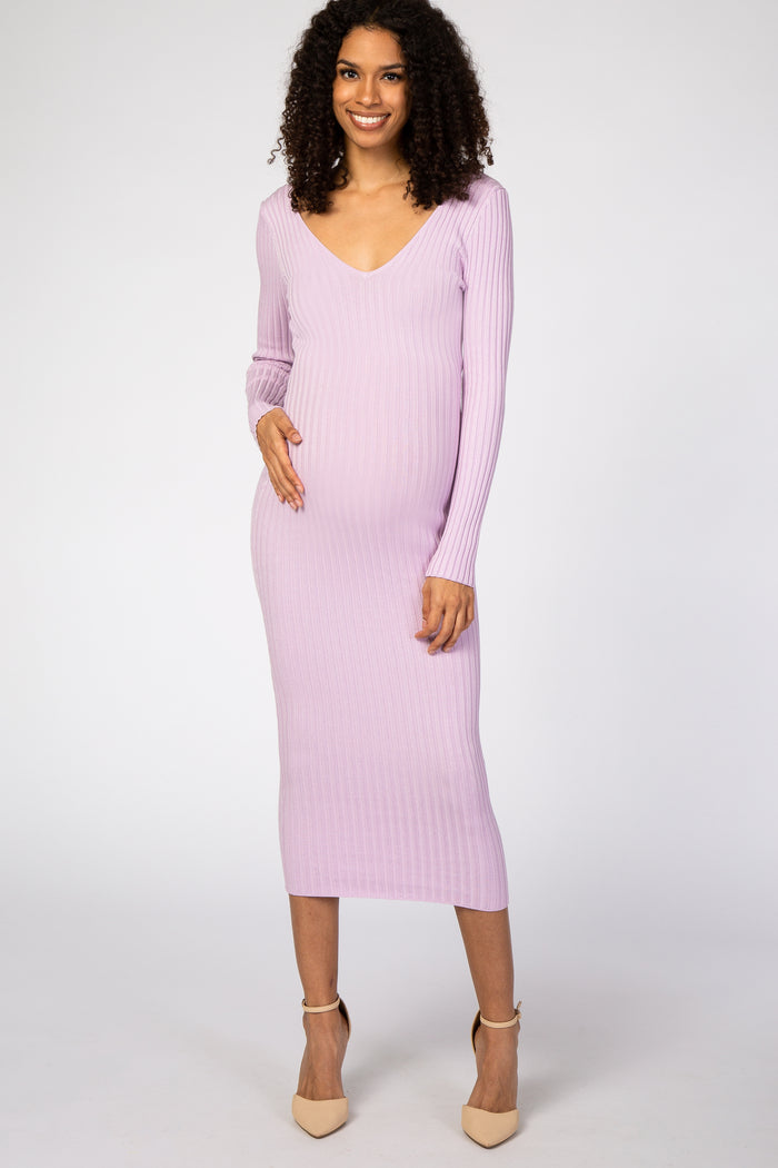 woman wearing a lavender ribbed long sleeve maternity dress and gently holding her baby bump