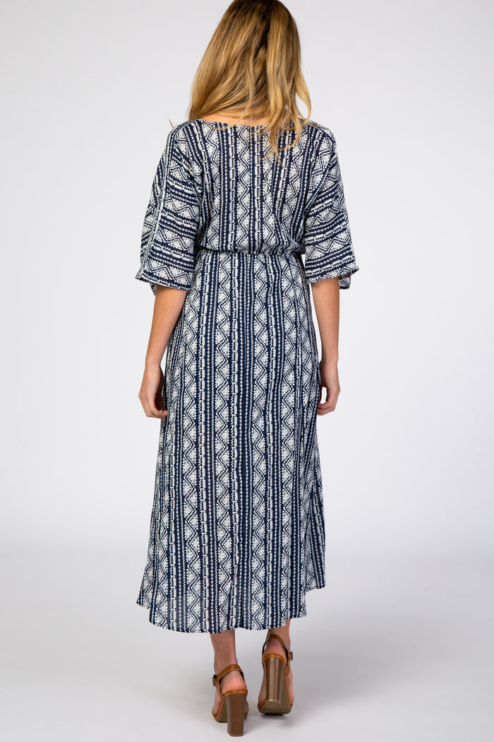 woman wearing a navy blue and white patterned maternity maxi dress with loose sleeves, shown from the back
