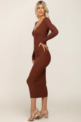woman wearing a brown ribbed knit midi dress with a deep v-neckline and long sleeves