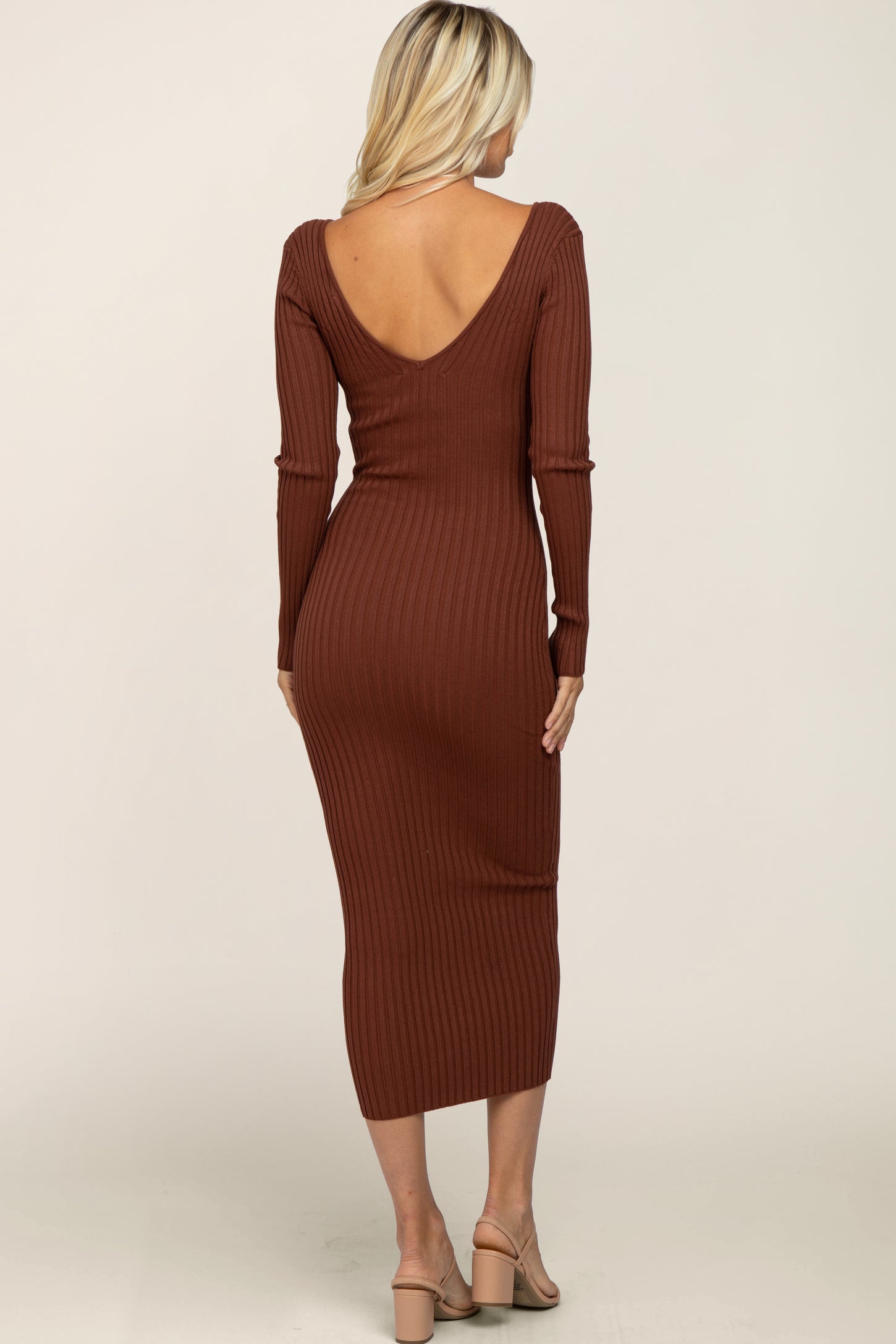 woman wearing a brown ribbed long sleeve midi dress with a low back design