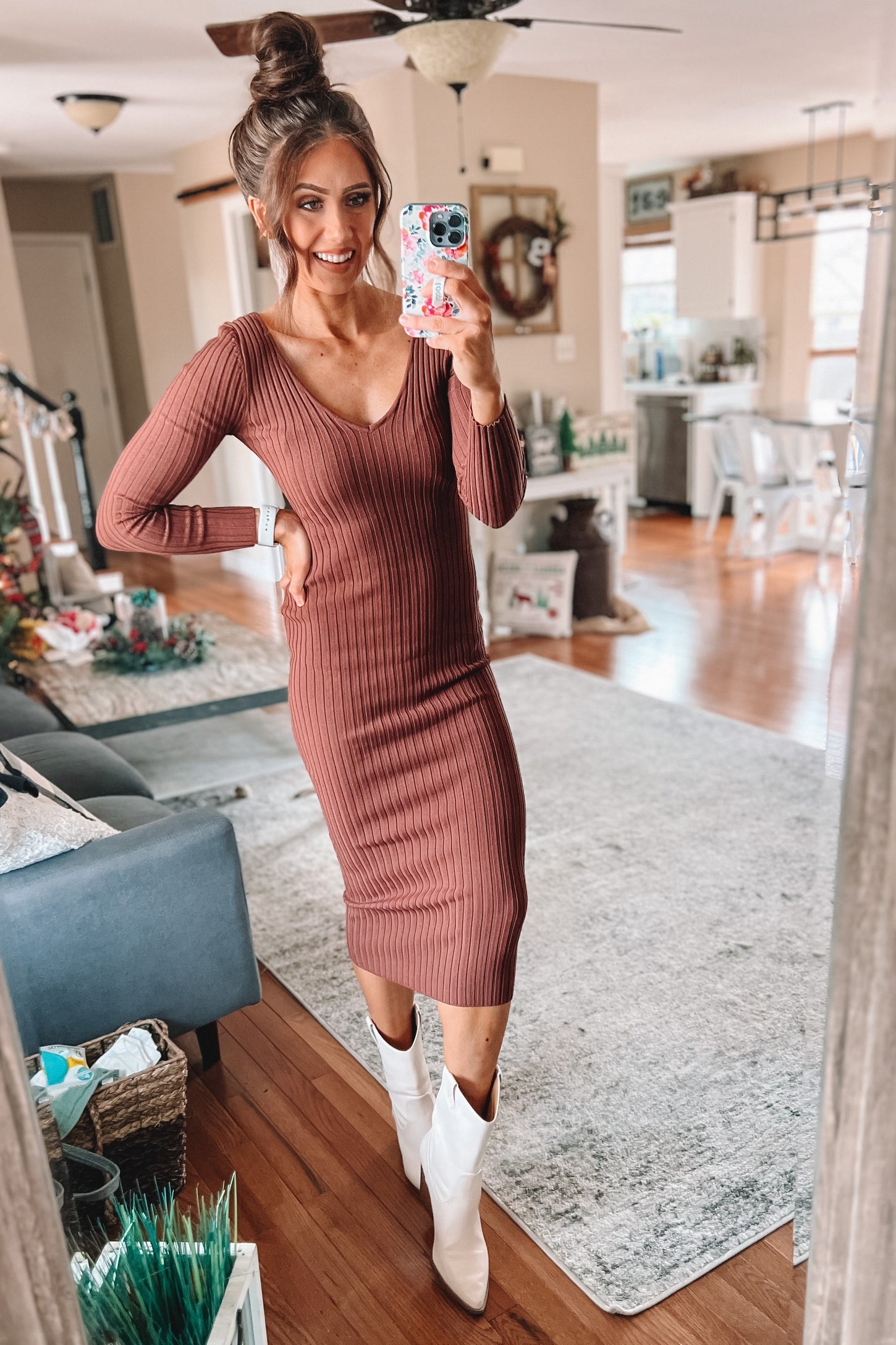 woman wearing a brown ribbed long sleeve midi dress and white cowboy boots, posing in a living room setting