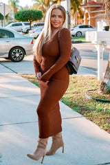 woman wearing a brown ribbed knit long sleeve dress and beige high-heeled boots, carrying a black handbag