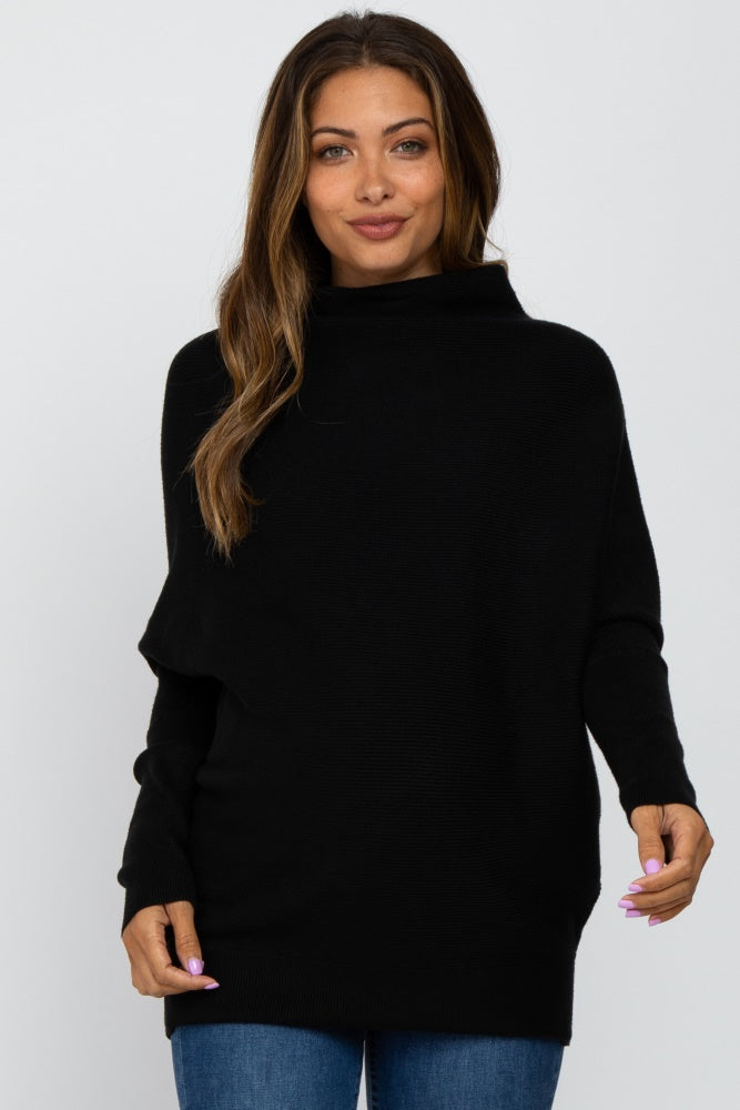 woman wearing a black oversized maternity sweater with a high neckline and long sleeves