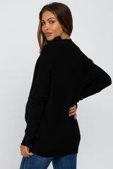 woman wearing a black oversized maternity sweater, showcasing a relaxed fit from the back with long sleeves
