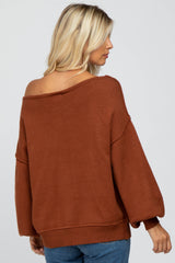 woman wearing a rust-colored off-the-shoulder oversized sweater with balloon sleeves