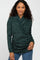 woman wearing a dark green wrap-style sweater with a textured finish and long sleeves, paired with blue jeans