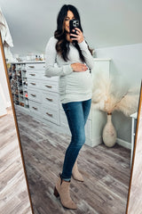 pregnant woman in grey long sleeve maternity top and blue jeans taking mirror selfie in a walk-in closet