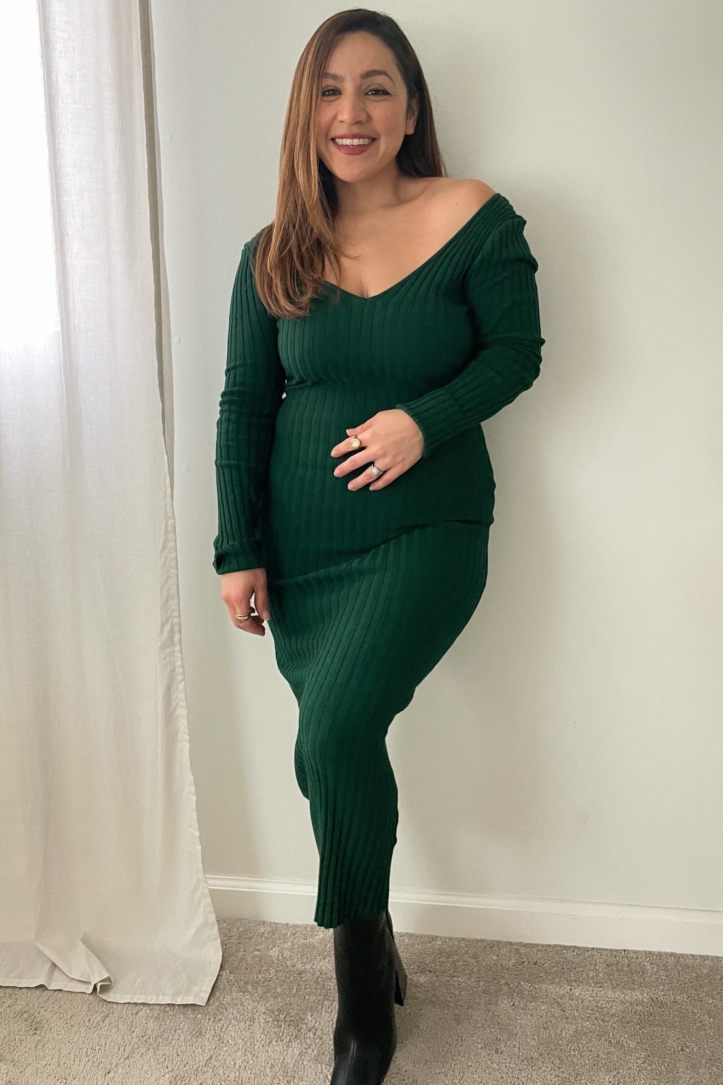 woman wearing a green ribbed off-the-shoulder long sleeve dress and black knee-high boots