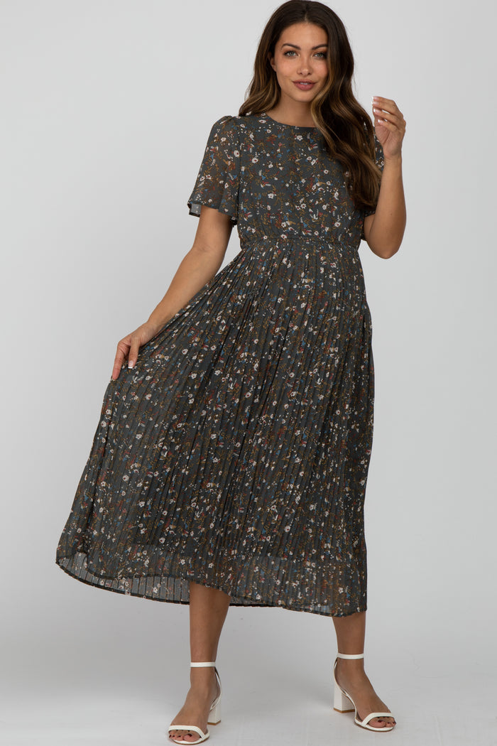 woman wearing a floral print maternity dress with short sleeves and a pleated skirt, posing and smiling