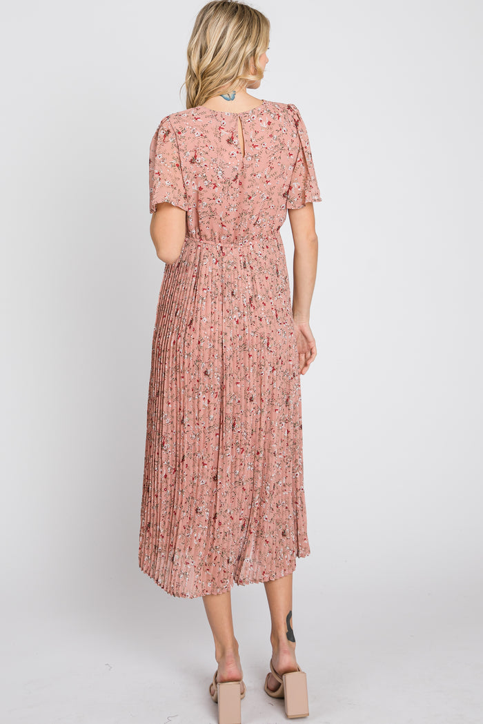 woman wearing a pink floral pleated midi dress with short sleeves, view from the back