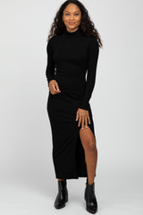 woman wearing a black long sleeve ribbed maxi dress with a side slit and black ankle boots