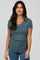 woman wearing a teal v-neck short sleeve fitted top with a gathered side detail and stylish casual look
