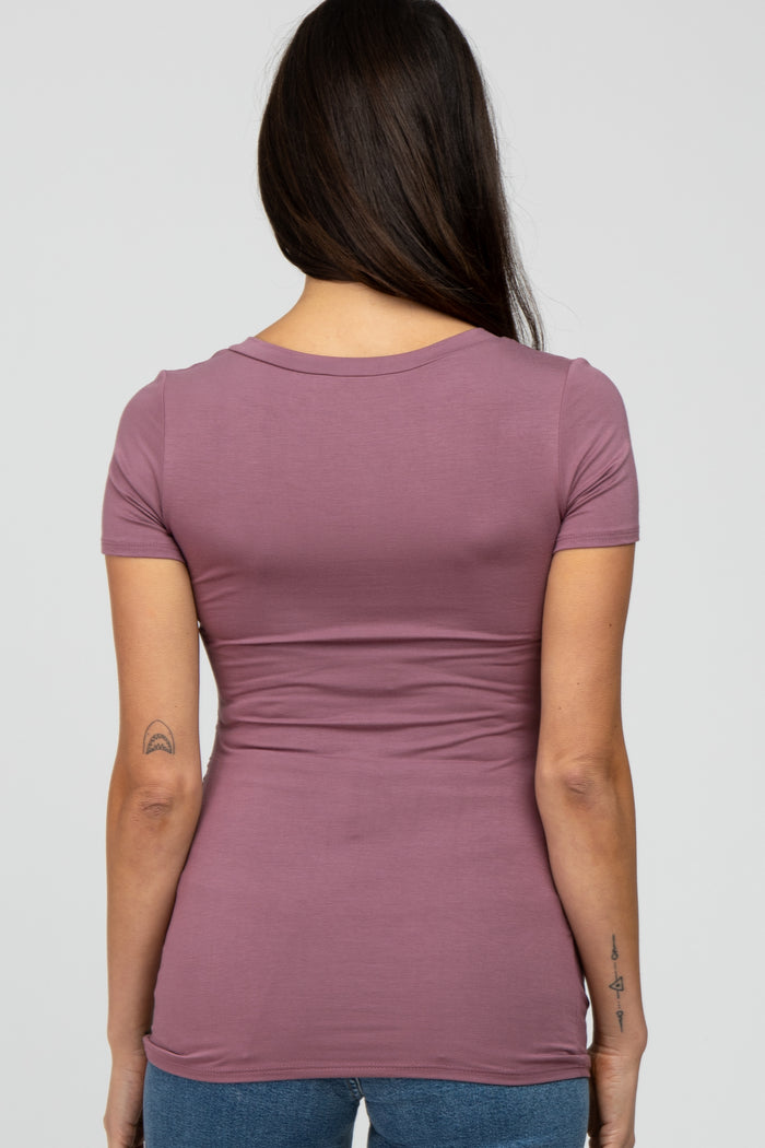 Back view of a woman with long dark hair wearing a mauve short sleeve t-shirt and blue jeans