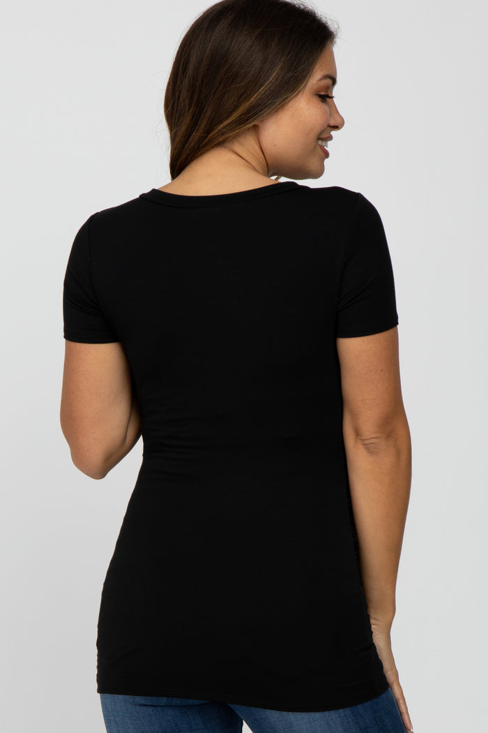 Back view of a woman wearing a fitted black short sleeve t-shirt and blue jeans