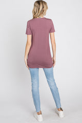 woman wearing a long mauve t-shirt with a relaxed fit and distressed light blue skinny jeans, viewed from the back