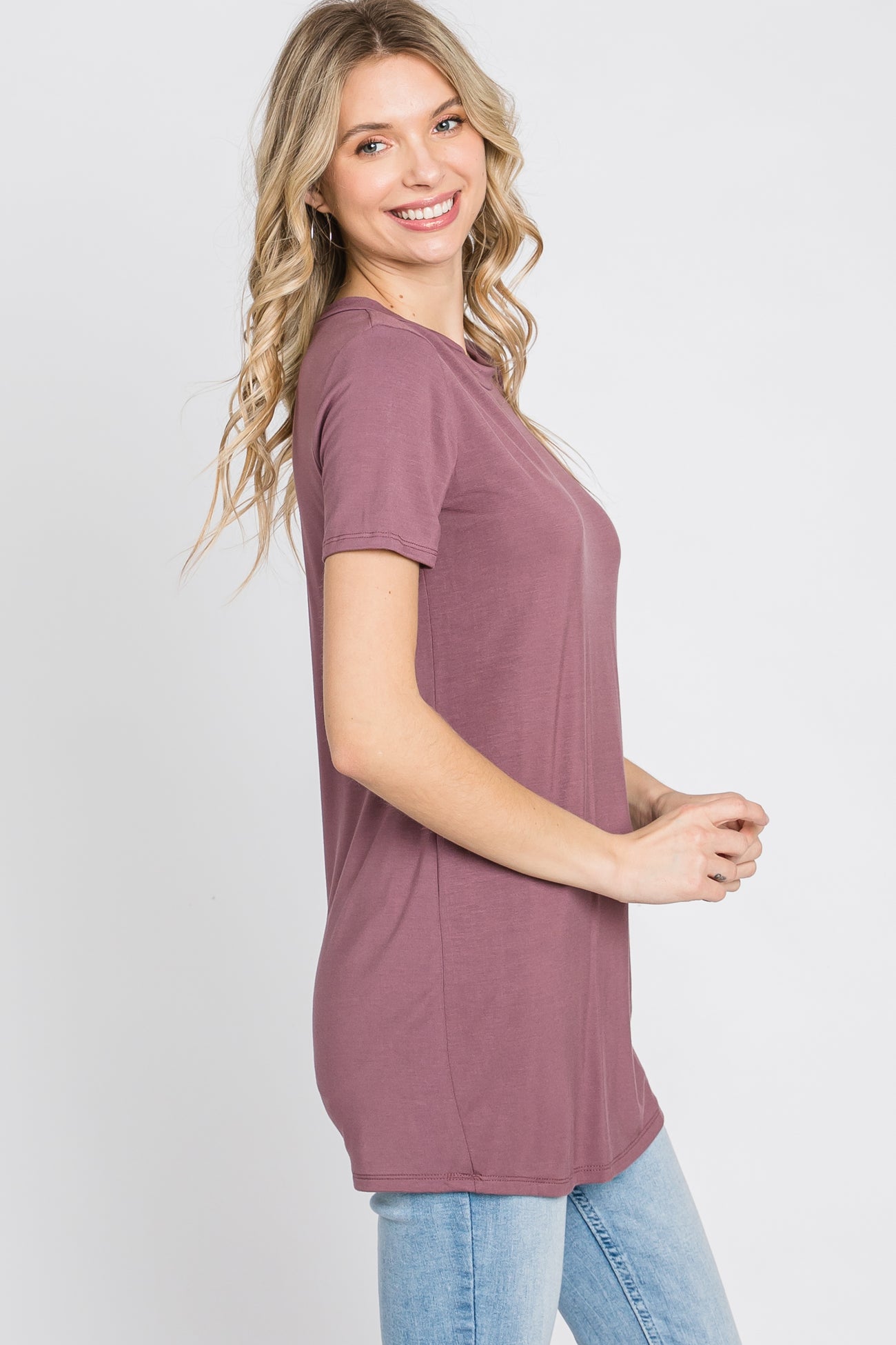 woman wearing a mauve short sleeve tunic top with a relaxed fit and smiling