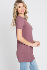 woman wearing a mauve short sleeve tunic top with a relaxed fit and smiling