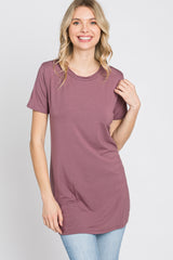 woman wearing a mauve short sleeve tunic top with a round neckline and relaxed fit, smiling at the camera