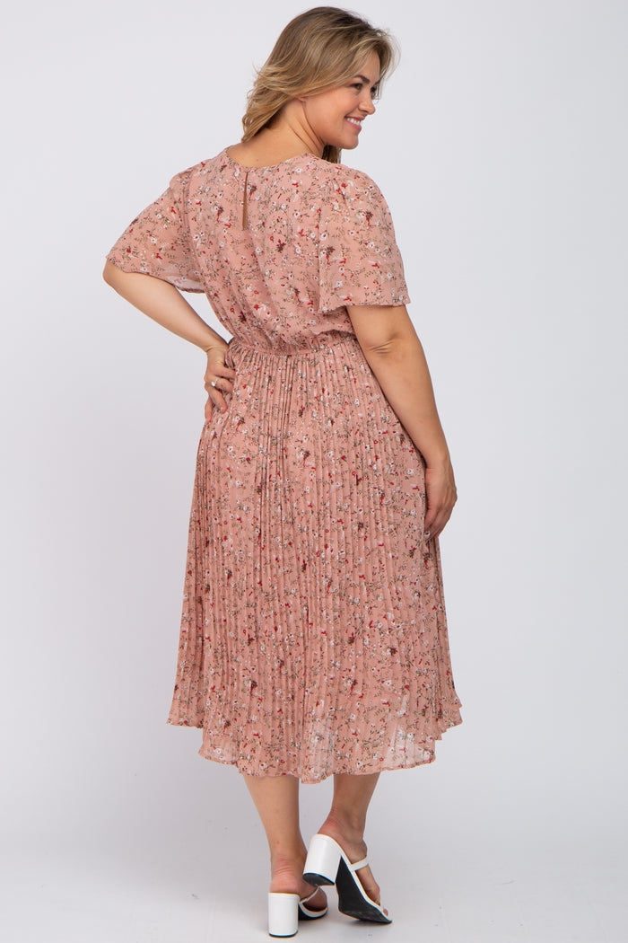 woman wearing a blush pink floral pleated maternity dress with short sleeves, showing a relaxed fit from the back