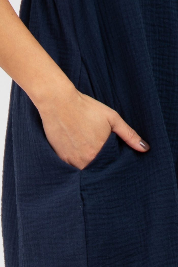 navy blue dress with a textured fabric and side pockets, showing a model's hand in a pocket