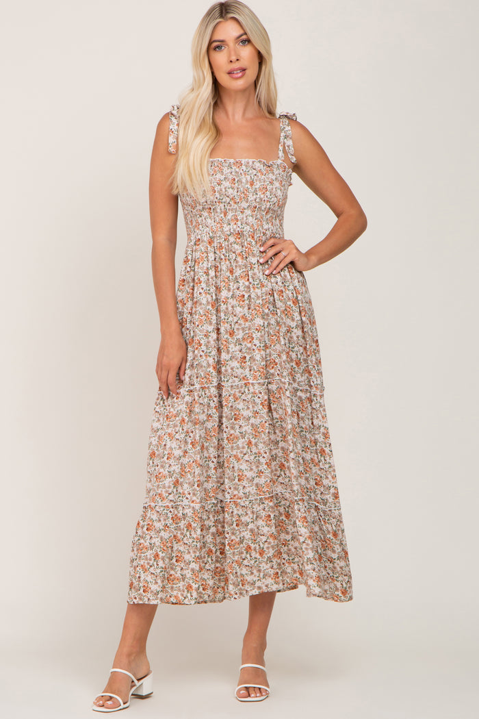 woman wearing a floral maxi dress with square neckline and tie shoulder straps