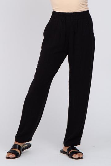 woman wearing black lightweight straight-leg pants with an elastic waist and styled with black sandals