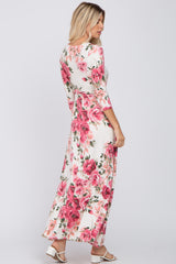 woman wearing a floral long sleeve maxi dress with a fitted bodice and flowing skirt