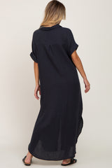 woman wearing a navy blue short sleeve maxi dress with a back slit and rolled sleeves