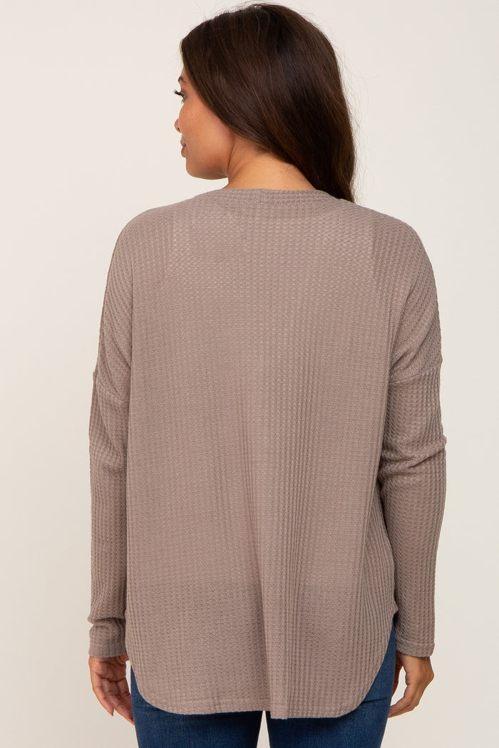 woman wearing a taupe long sleeve maternity top with a relaxed fit and back yoke detail