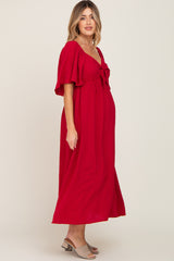 pregnant woman wearing a red short sleeve maternity maxi dress with a front tie and swiss dot texture