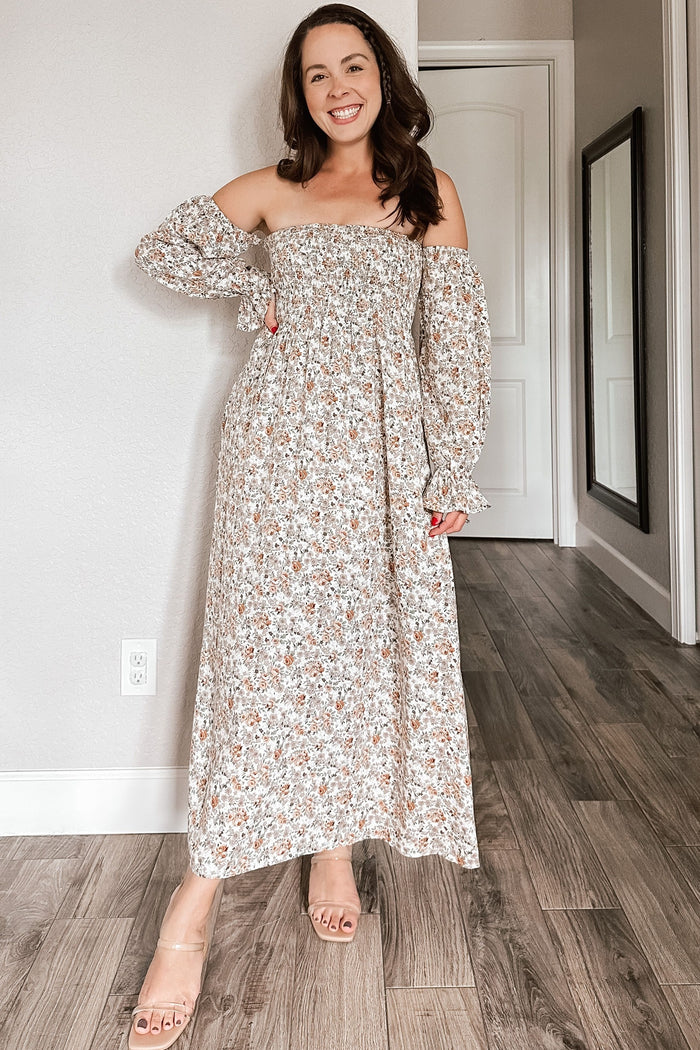 woman wearing a floral off-the-shoulder maxi dress with elastic sleeves and a flowy silhouette