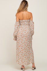 woman wearing a floral off-the-shoulder maternity maxi dress with long sleeves, showing a relaxed fit and back detail