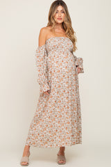 woman wearing a floral off-the-shoulder maternity maxi dress, showcasing her baby bump