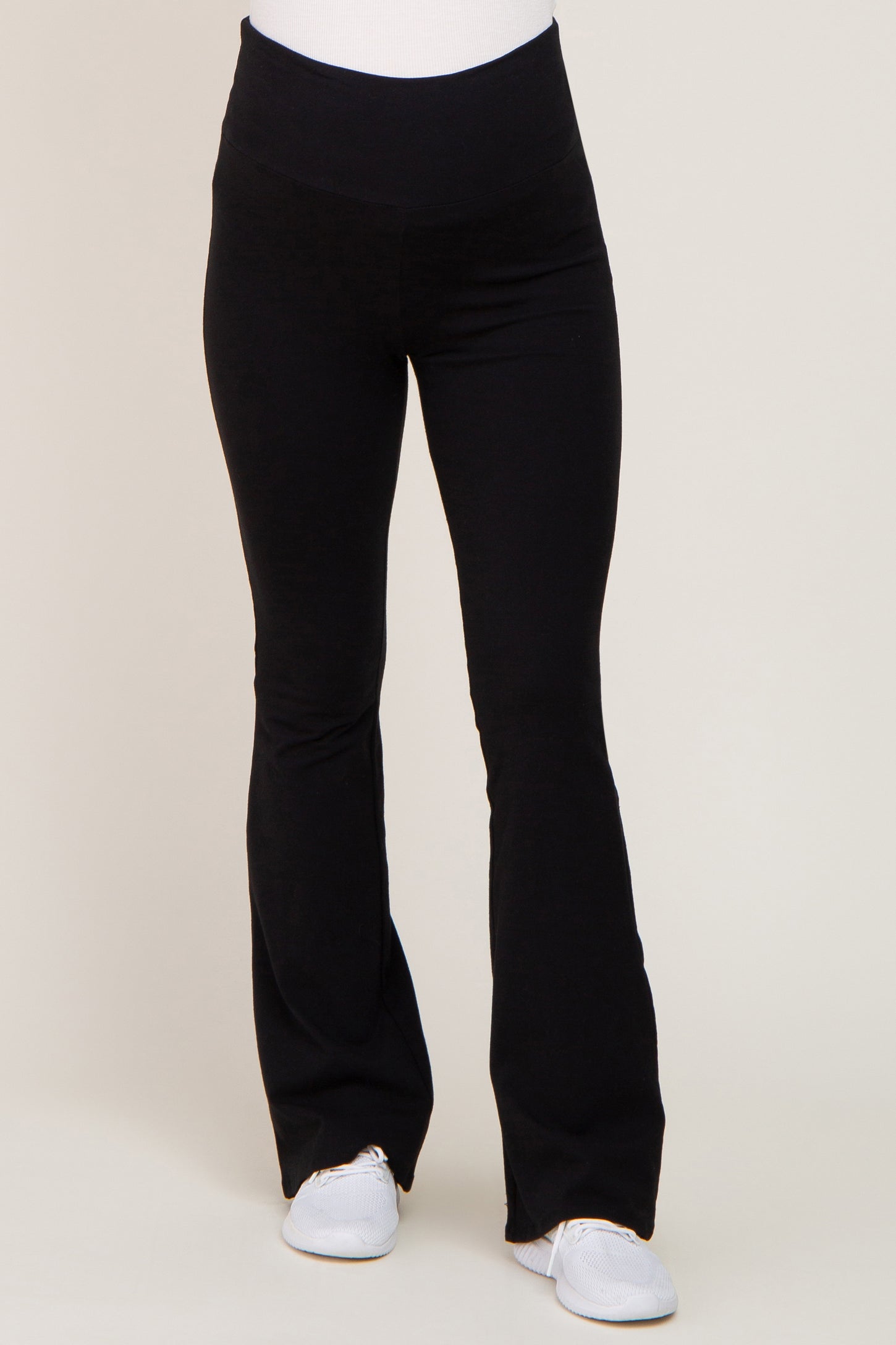woman wearing black maternity leggings with a flared hem and a stretchy waistband