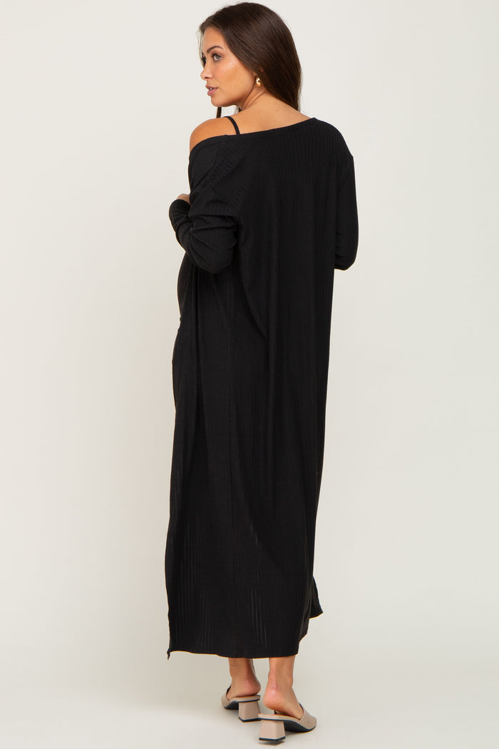 woman wearing a long black maternity dress with a relaxed fit and open back, showcasing her baby bump