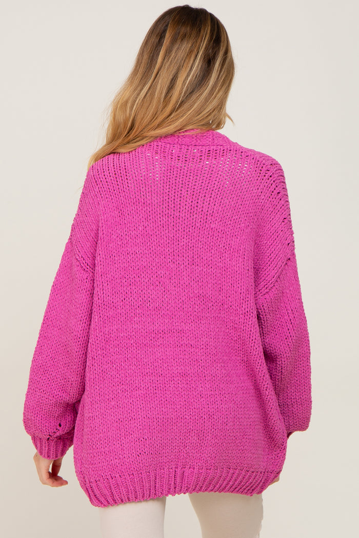 woman wearing a bright pink oversized knit maternity sweater, view from the back