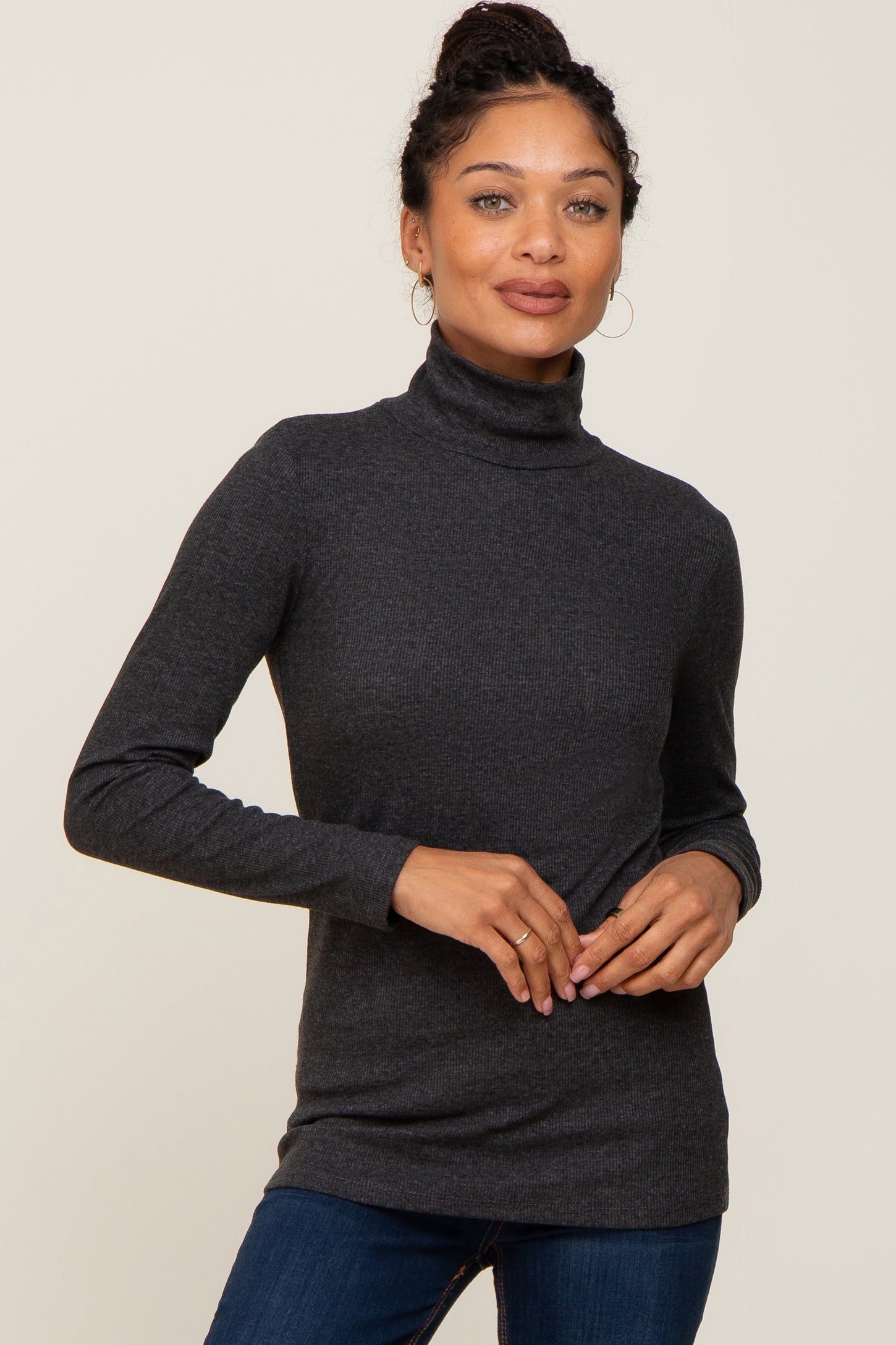 woman wearing a charcoal grey ribbed long sleeve turtleneck top and blue jeans