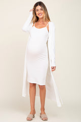 woman wearing a white ribbed maternity dress with a long cardigan and showing her baby bump