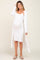 woman wearing a white ribbed maternity dress with a long cardigan and showing her baby bump