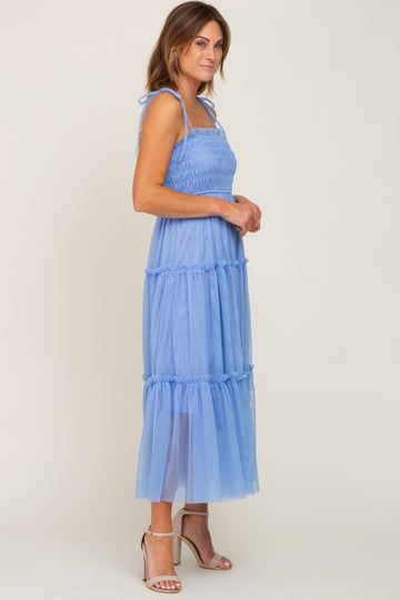 woman wearing a light blue tiered maxi dress with smocked bodice and spaghetti straps