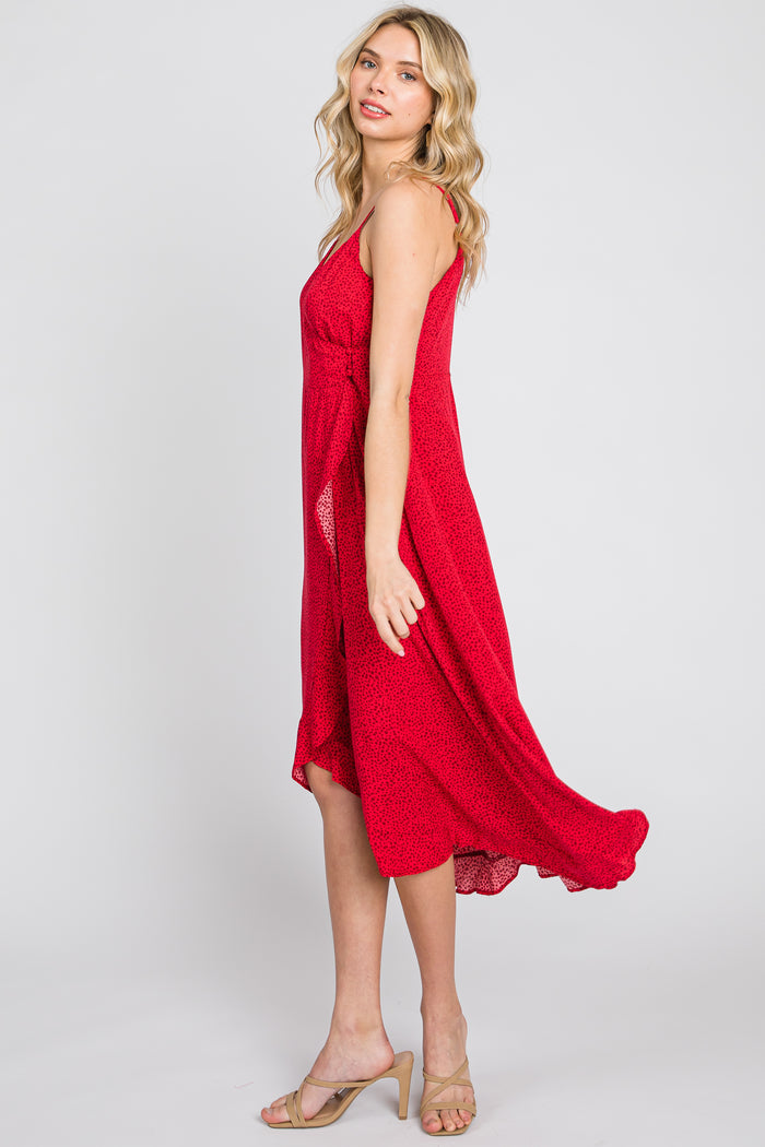 woman wearing a red floral midi dress with a flowing silhouette and spaghetti straps