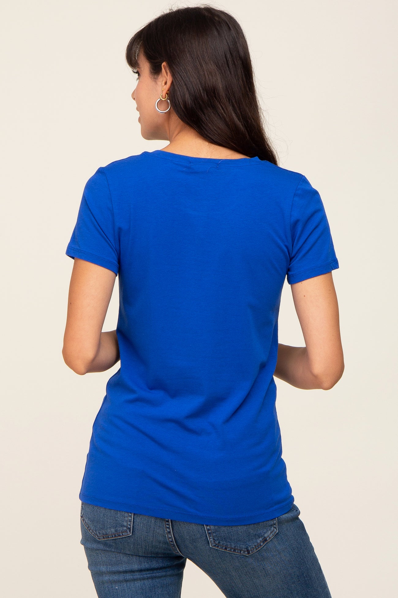 woman wearing a royal blue short sleeve t-shirt with a relaxed fit, viewed from the back