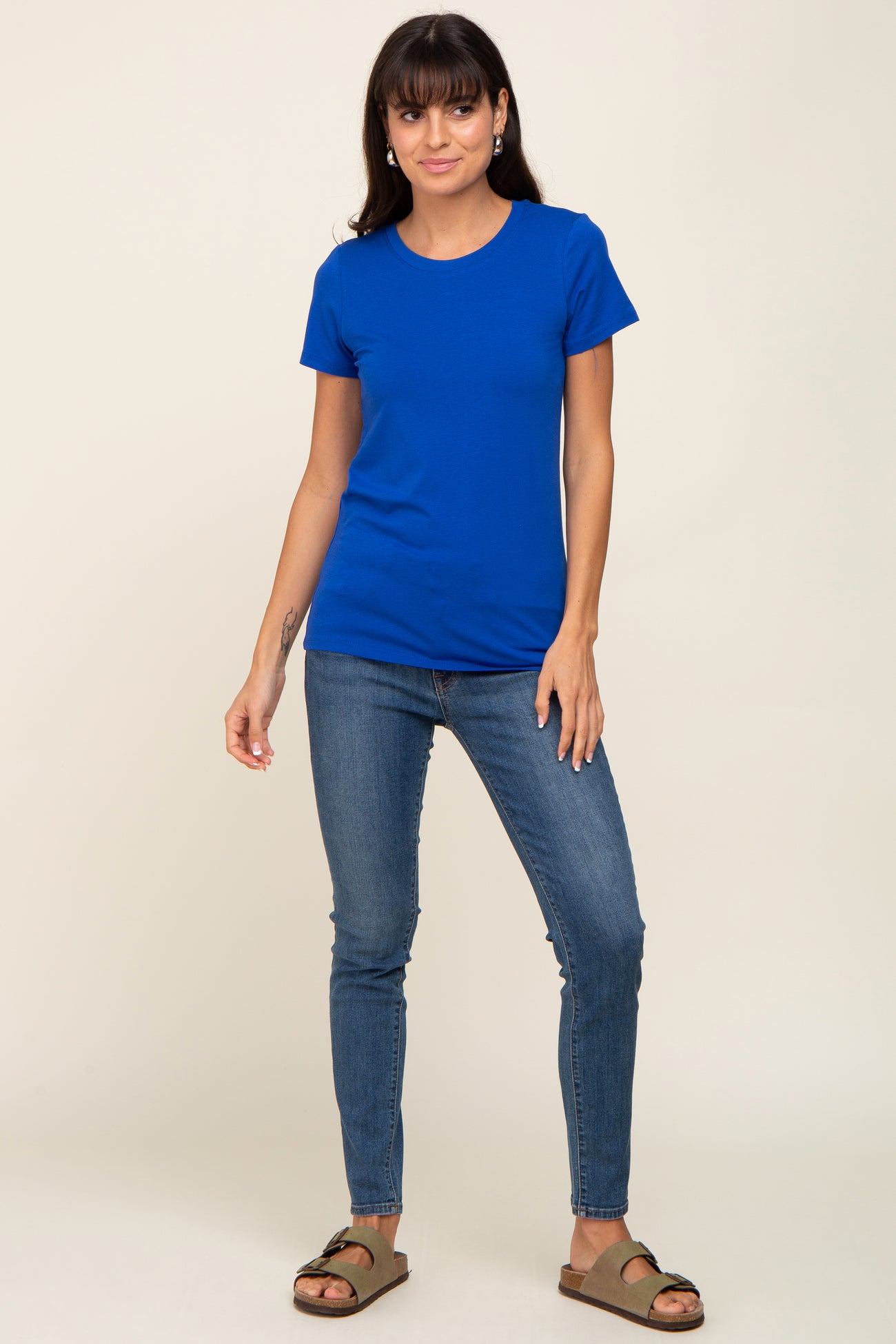woman wearing a bright blue short sleeve t-shirt with a fitted silhouette and paired with skinny jeans