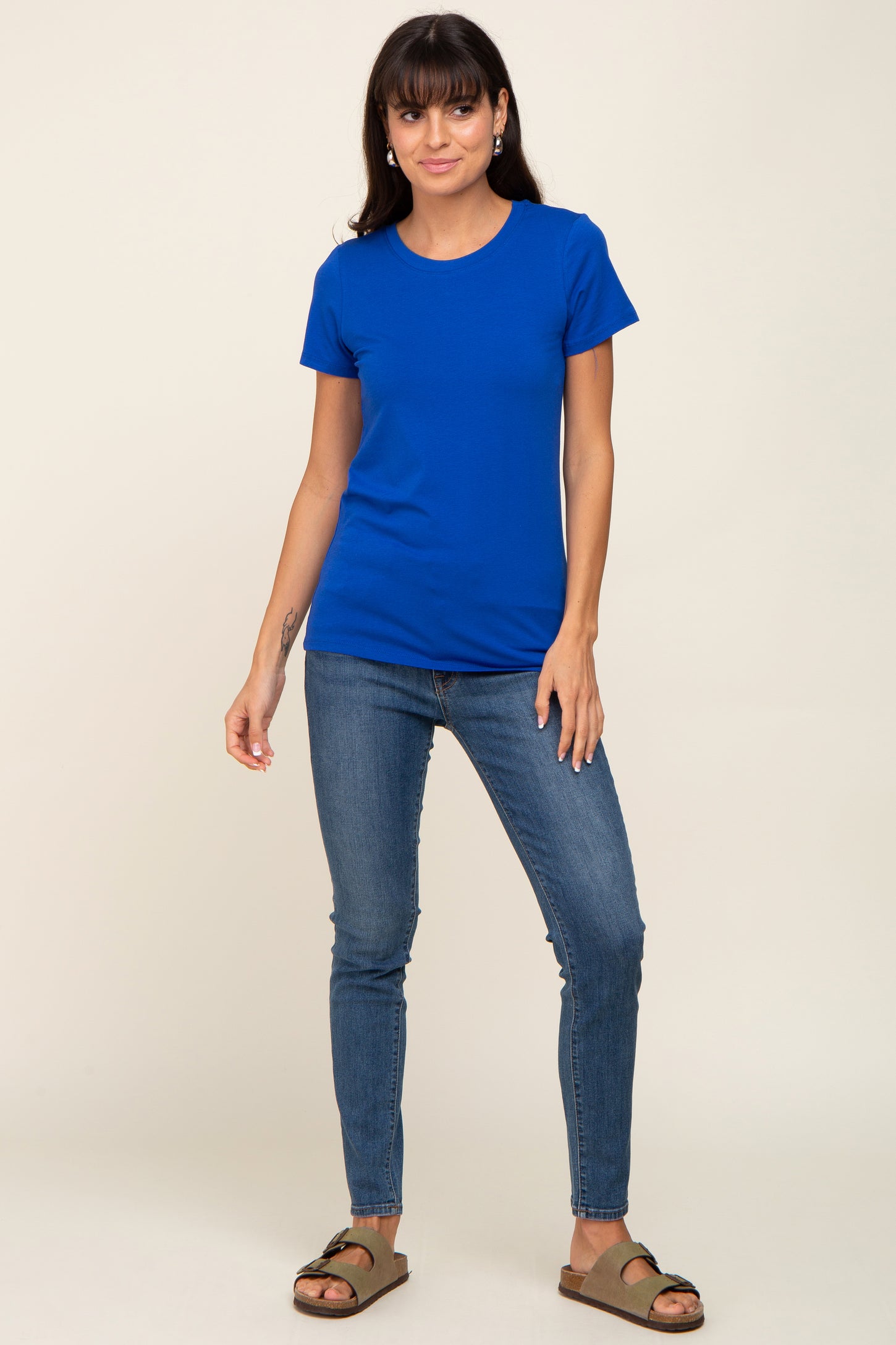 woman wearing a bright blue short sleeve t-shirt with a fitted silhouette and paired with skinny jeans