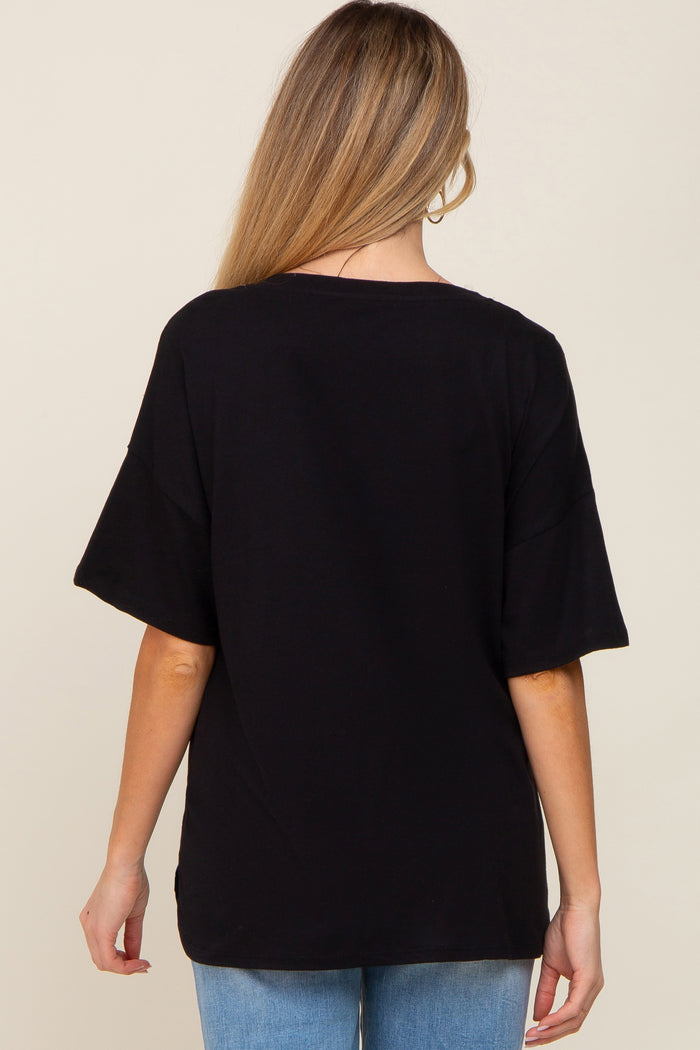 Back view of a woman wearing a black oversized short sleeve t-shirt and blue jeans