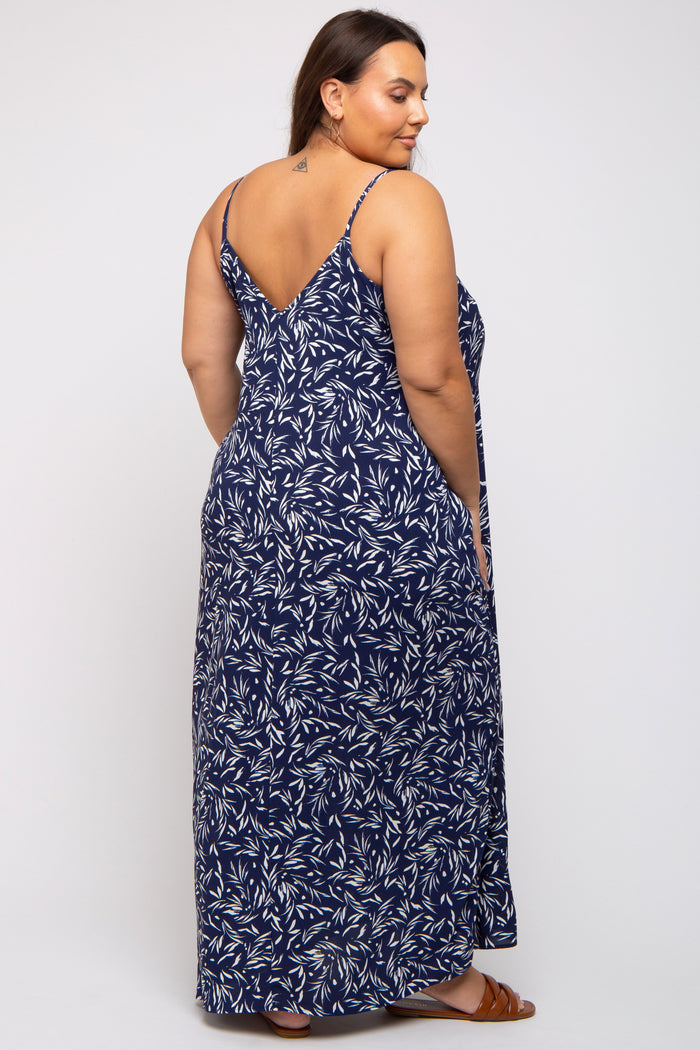 woman wearing a navy maxi dress with a leaf pattern and adjustable spaghetti straps, shown from the back